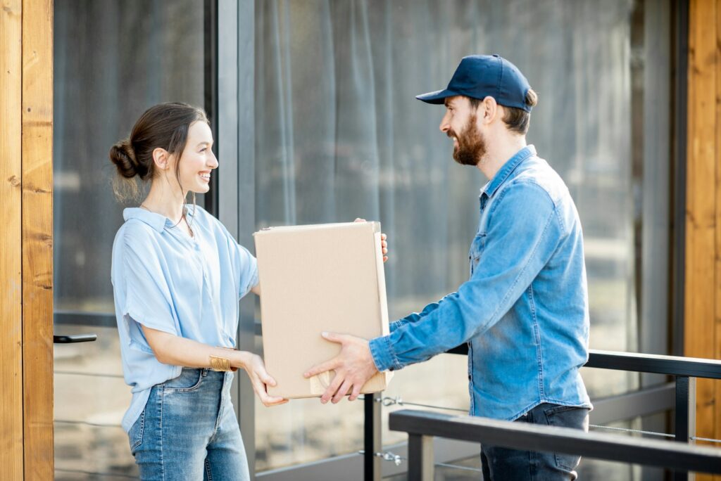 Delivery man bringing goods home for a woman client